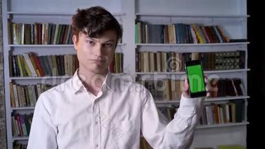 布鲁内特曼正在<strong>展示</strong>智能手机的绿色屏幕，如标牌、摄像头观看、通讯概念、<strong>图书</strong>馆等
